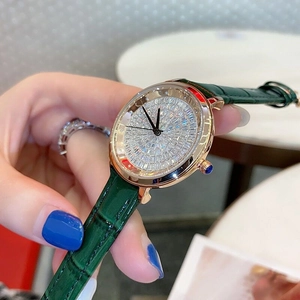 Detail of luxury rose gold watch with full diamond dial and green leather strap on wrist