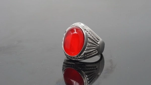 Detailed view of silver stainless steel ring with a large oval red gemstone inlay
