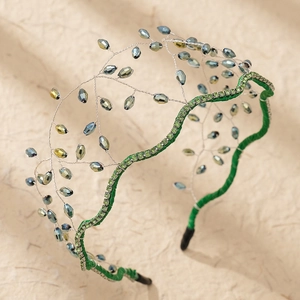 Close-up of handmade green fabric headband with crystal beads and silver wire detail