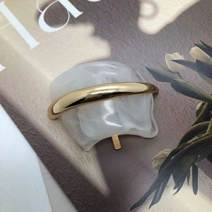 Retro white marble resin hair clip with gold metal bar accessory on a magazine cover