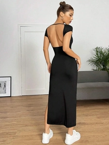 Detailed back view of a slim fit black knit dress with a deep U-shaped open back and side slit