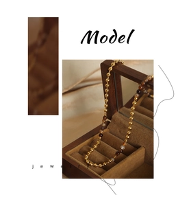 Dettaglio della collana di perline con pietre naturali e perle dorate in scatola di legno