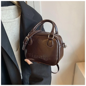 Detail of dark brown mini handbag with embossed Yimeiya logo and wrinkled texture finish