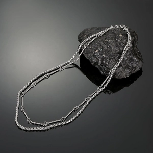 Double-layered silver titanium steel necklace with box chain and ring detail on rock