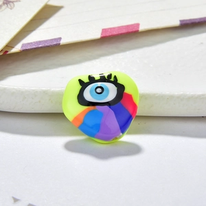 Macro detail of heart-shaped evil eye resin charm for DIY jewelry with vibrant neon finish