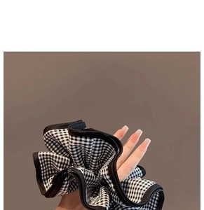 Détail d'un chouchou géant à carreaux noir et blanc avec texture plissée en tissu doux