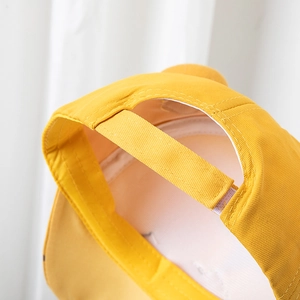 Détail de la casquette de baseball jaune enfant avec fermeture velcro réglable à l'arrière