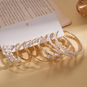 10-piece gold pearl hoop earring set with twisted metal designs on display card