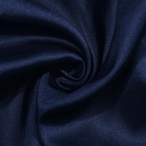 Dettaglio macro del tessuto satinato blu navy con texture setosa e finitura lucida