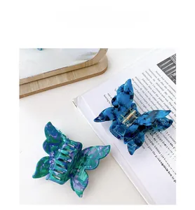 Detailed view of acetate butterfly hair claws with elegant marble textures and metal springs