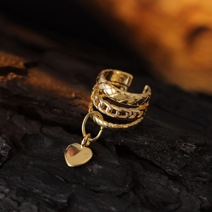 Detailed macro view of layered gold heart clip-on earrings with textured patterns