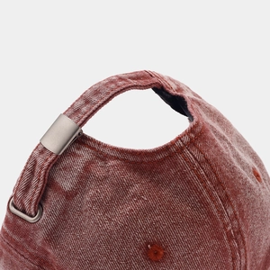 Close-up of red-brown washed denim baseball cap with metal buckle and stitching