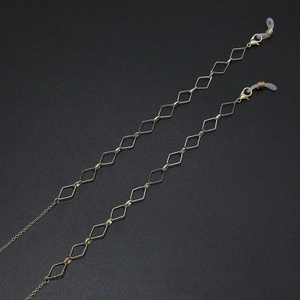Close-up of golden geometric diamond link chain for glasses and face masks with silicone loops