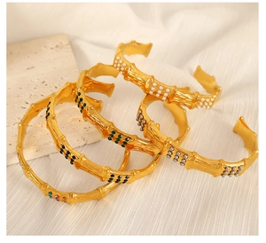 Set of four gold bamboo-style C-shaped bangles with pearls and colorful gemstones