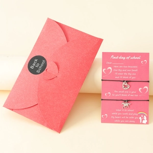 Detail of woven bracelets with horse charms on back to school card in red envelope