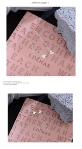 Detailed view of silver clover drop earrings with long chain tassels from different angles