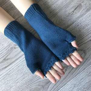 Detailed close-up of blue knitted fingerless gloves with delicate yellow flower embroidery