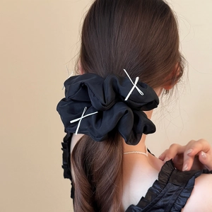 Elegant large black scrunchie with white cross straps on a ponytail hairstyle