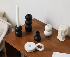 Macro detail of matte ceramic geometric candle holders in black and white finish