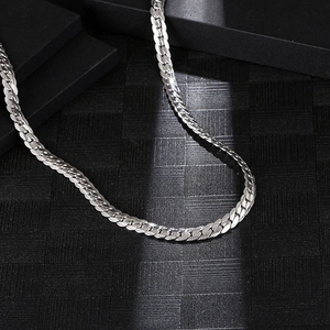 Polished silver titanium steel flat Cuban chain necklace for men and women on black background