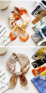 Detailed view of assorted printed silk scarves featuring vibrant floral and leopard patterns
