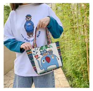 Detailed view of the ethnic woven strap and colorful cartoon animal prints on the canvas tote