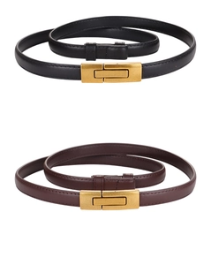 Close-up of black and brown thin leather belts with elegant golden metal buckles