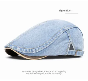 Detail of light blue denim flat cap featuring yellow stitching and adjustable metal buckle