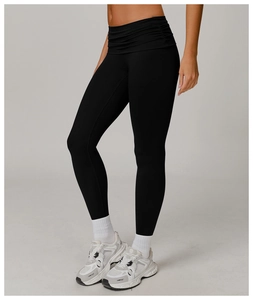 Close-up of high-waist black yoga pants with pleated waistband and tummy control design