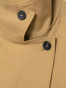 Macro shot of camel trench coat lapels featuring premium twill fabric and matte buttons