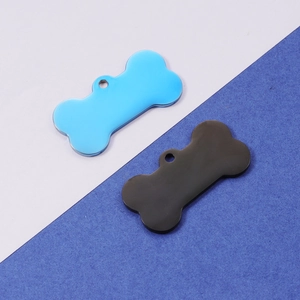 Close-up of bone-shaped metal pet tags in blue and black colors for DIY accessory making