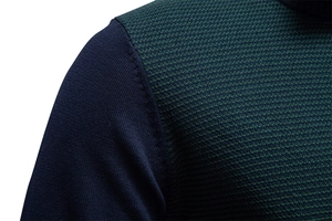 Gros plan de la manche en tricot bleu marine et du motif géométrique vert foncé