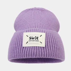 Detailed view of lavender knit beanie with a woven patch and thick vertical ribbed texture