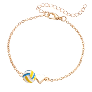 Détail de breloques volleyball et cœur doré sur un bracelet à chaîne à maillons ajustable