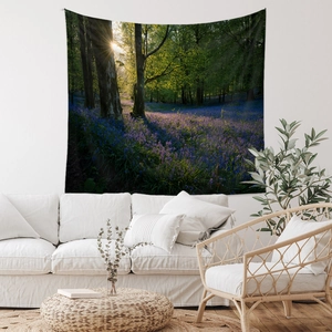 Detail view of a forest sunrise wall tapestry hanging in a minimalist living room