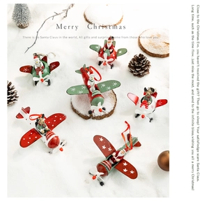 Christmas metal airplane ornaments with Santa and Snowman figures on snowy background