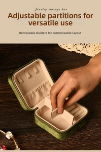 Detail view of green velvet jewelry box showing removable dividers and flexible storage