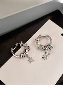 Detail view of silver zircon star tassel hoop earrings with sparkling crystal accents