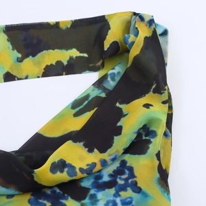 Detailed macro view of abstract tie-dye print on breathable chiffon dress fabric