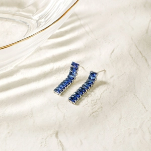 Detail showing curved silver studs with navy blue step-cut square cubic zirconia stones