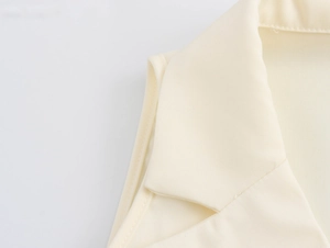 Detail of elegant beige blazer collar and shoulder structure with woven fabric texture