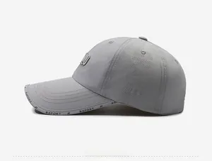 Close-up of light gray quick-dry sport cap with side laser-cut vents and metal logo