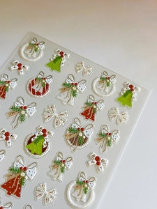 Close-up of 3D embossed Christmas nail art stickers with wreaths, trees and bells
