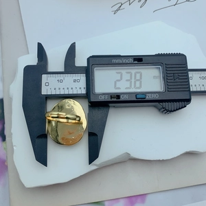 Close-up measurement of gold irregular floral ring with 23.8mm top width detail
