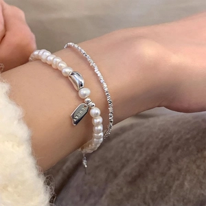 S925 sterling silver freshwater pearl bracelet set with LUCKY tag on a hand model