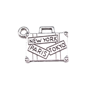Silver metal suitcase charm with engraved city names New York, Paris, and Tokyo