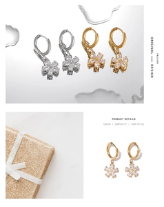 Macro detail of gold and silver flower hoop earrings with zircon petals and diamond center