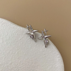 Detailed view of silver star earrings with square center stone on elegant stone surface