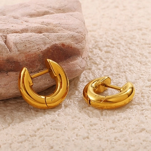 Chic gold-plated thick hoop earrings displayed on a natural stone textured background