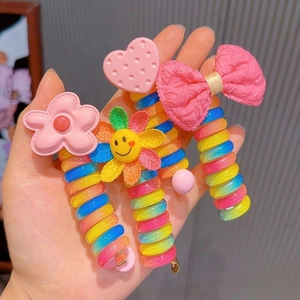 Close-up of colorful spiral phone cord hair ties with heart and sunflower charms